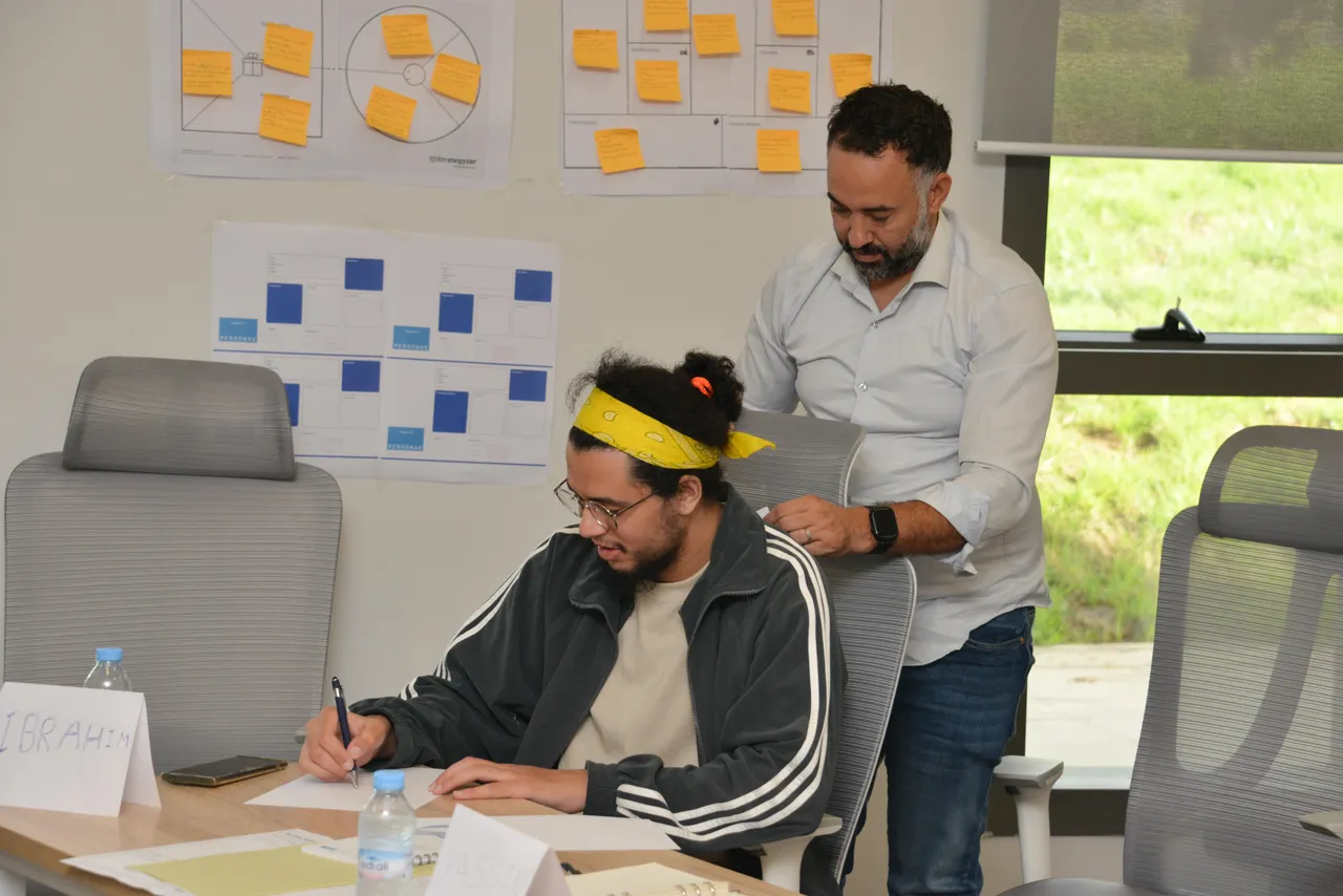 Mentor de l'EIC accompagnant un porteur de projet devant un mur d'idéation